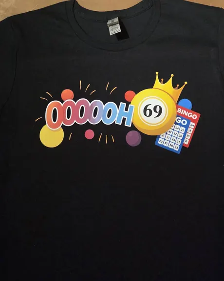 Chandail noir à plat, portant un visuel DTF humoristique : une boule de bingo couronnée, une carte de bingo et un lettrage coloré.